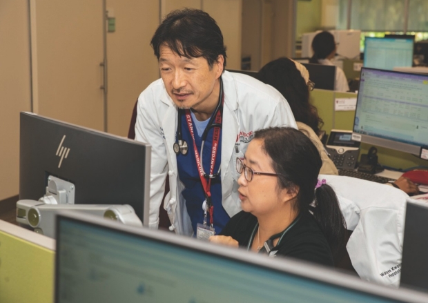 RAY KIM, MD (left), works with a team cell member.