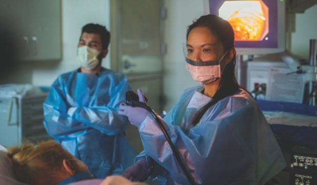 LINDA NGUYEN, MD (right), performs a procedure.